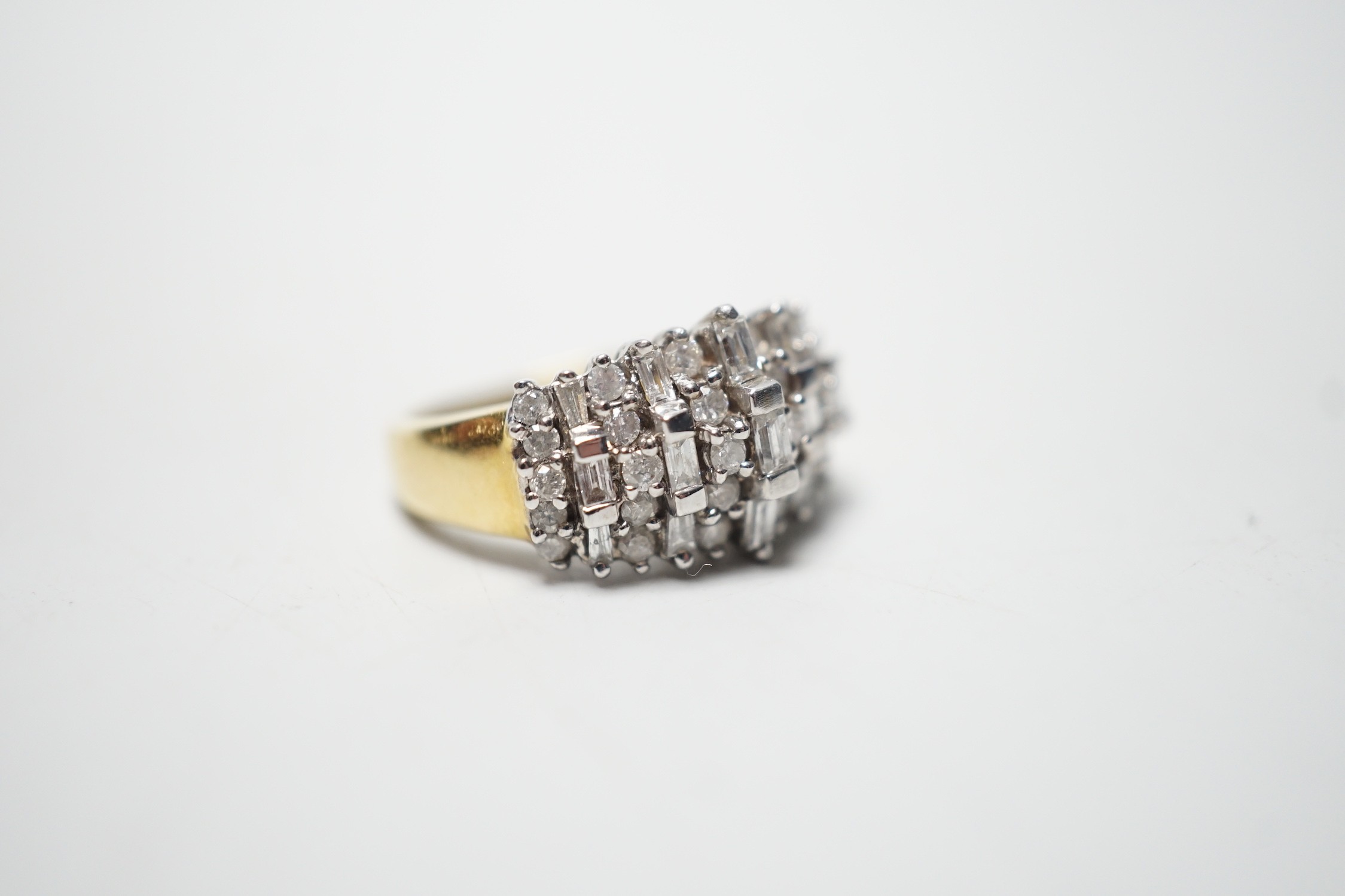 A modern yellow metal, round and baguette cut diamond set half hoop cluster ring, size L/M, gross weight 5.6 grams.